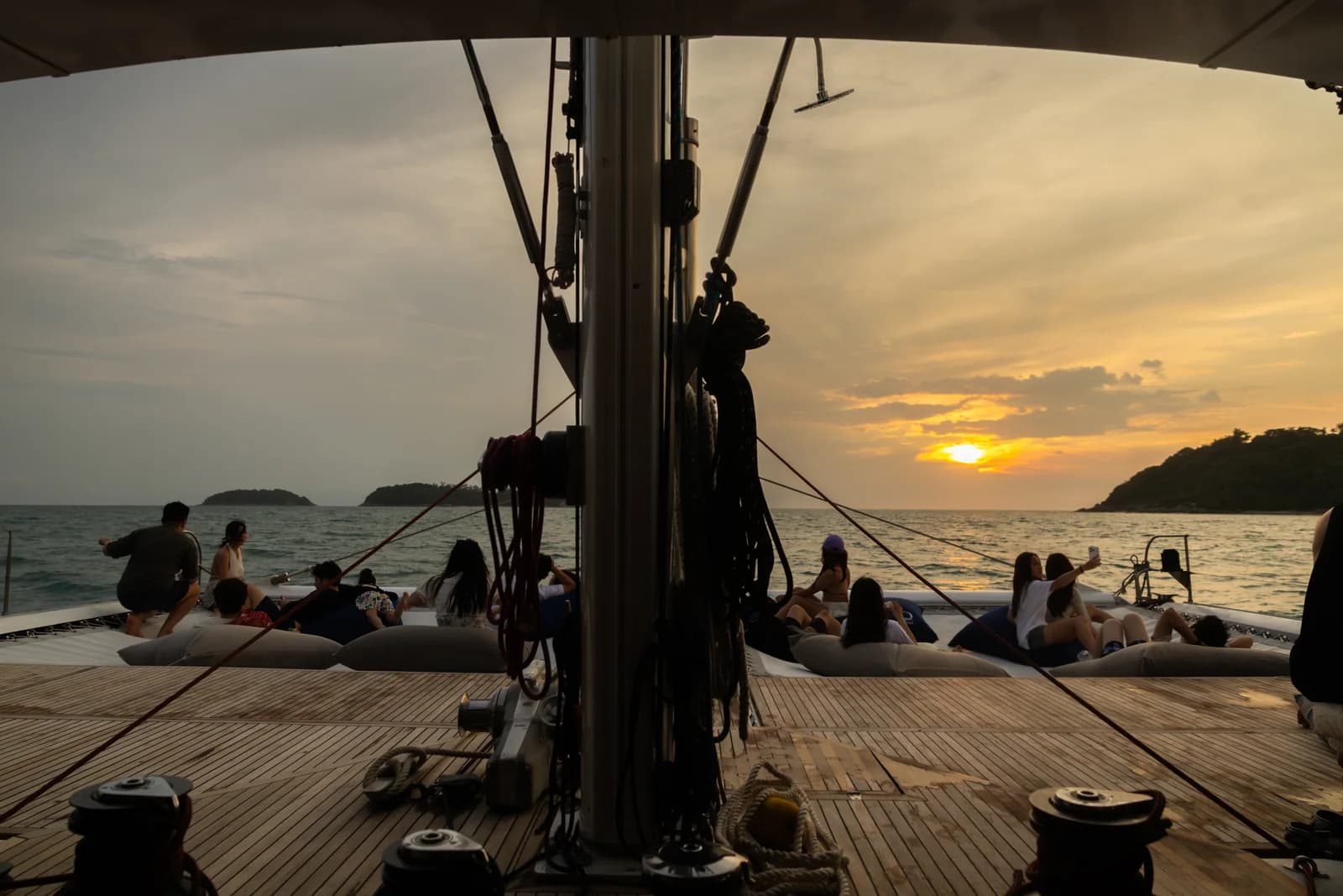 Guests on the OMBRE bow as the sun sets over the sea
