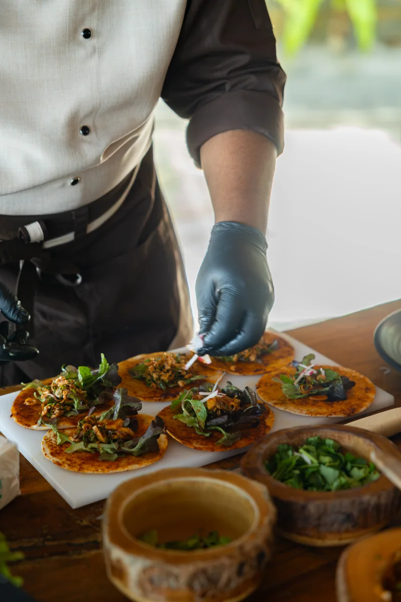 A chef wearing gloves prepares food at a counter